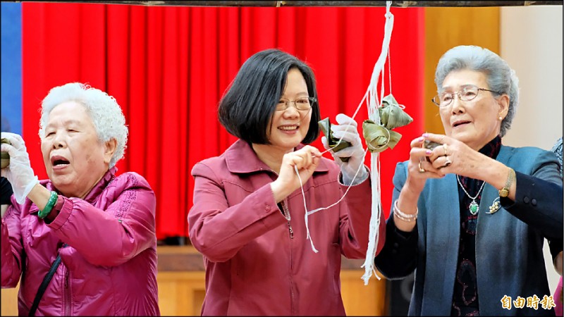 蔡英文總統（中）昨赴貢寮區漁會，和阿嬤們一起包粽子。針對前行政院長賴清德反對手機納民調，她表示須與時俱進，不能因噎廢食。（記者林欣漢攝）