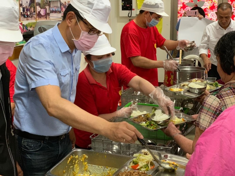 康福餐今舉辦捐贈儀式，立委劉建國（左一）幫長輩打菜。（劉建國服務處提供）