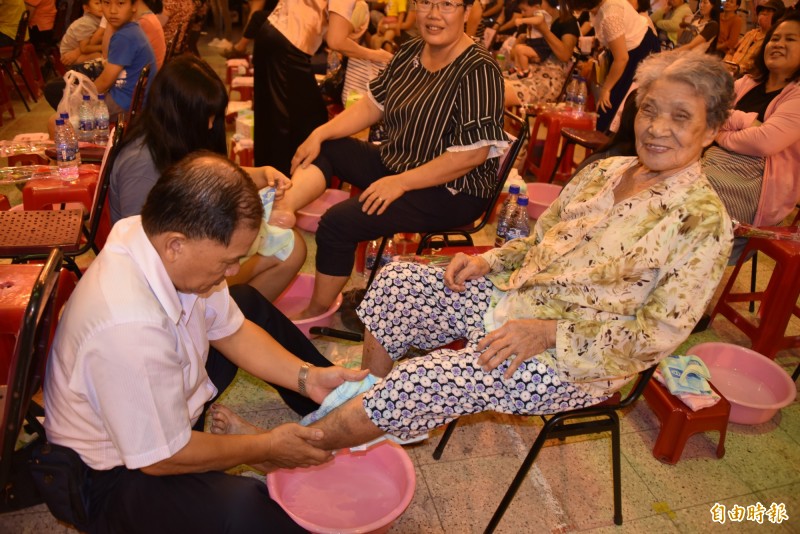 98歲的蘇鄭玉帶由兒子幫她洗腳，感到很高興。（記者葉永騫攝）