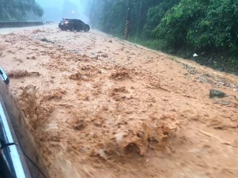 大雨導致南投縣埔里鎮台21線大坪頂路段宛如湍急野溪，泥流、石塊遍布，車輛差點受困。（李姓民眾提供）