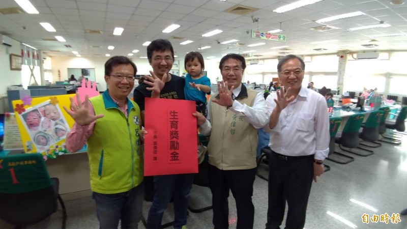 台南市長黃偉哲（右二）發六萬元生育津貼給連生五名子女的林建忠（左二）。（記者王俊忠攝）