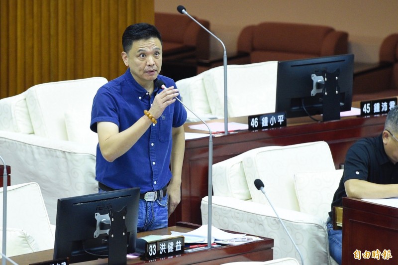 台北市議員洪健益質詢前先播放數張照片，草地上散落的保險套，說他昨天趁著非假日去拍的，拍到這樣的照片，問柯文哲知不知道是什麼。（記者叢昌瑾攝）