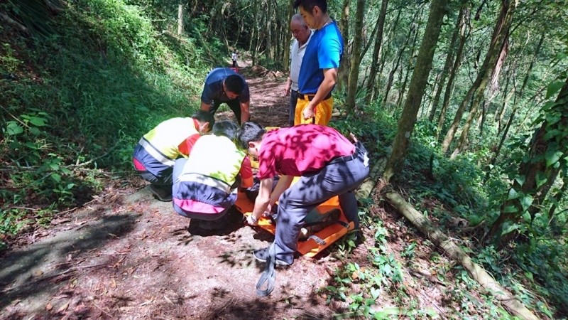 南投縣消防人員將採筍發生跌倒意外的林姓老翁，利用擔架搬運下山情形。（記者謝介裕翻攝）