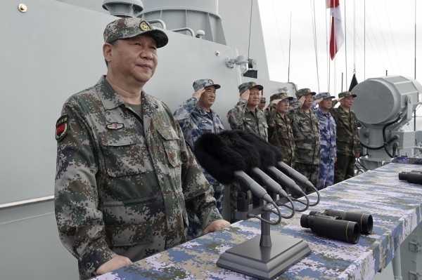美方承諾以《台灣關係法》保證台灣安全，中方回應，中國有決心、意志與能力統一台灣。圖為中共總書記習近平在軍艦上校閱艦隊。（美聯社資料照）
