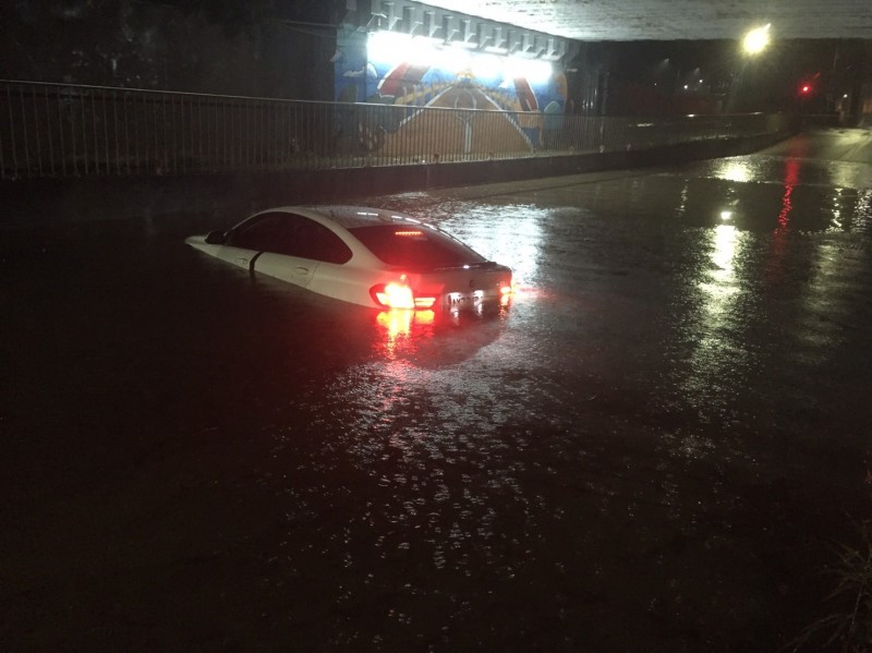 新竹市一名駕駛白色BMW名車的男子不理會現場警方的勸阻，執意闖入已封閉的元培街地下道，結果車子拋錨險些滅頂，經警消破窗搶救，男子和女乘客才順利逃出。（記者廖雪茹翻攝）