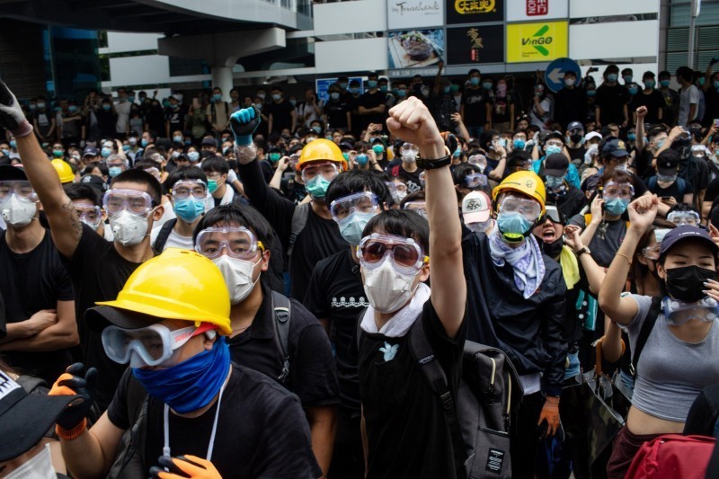 香港近日發起「反送中」行動，抗議港府強推《逃犯條例》修正案。圖為「反送中」群眾12日包圍香港立法會，當地警方使用催淚彈等工具驅離，引起嚴重警民衝突。（彭博）