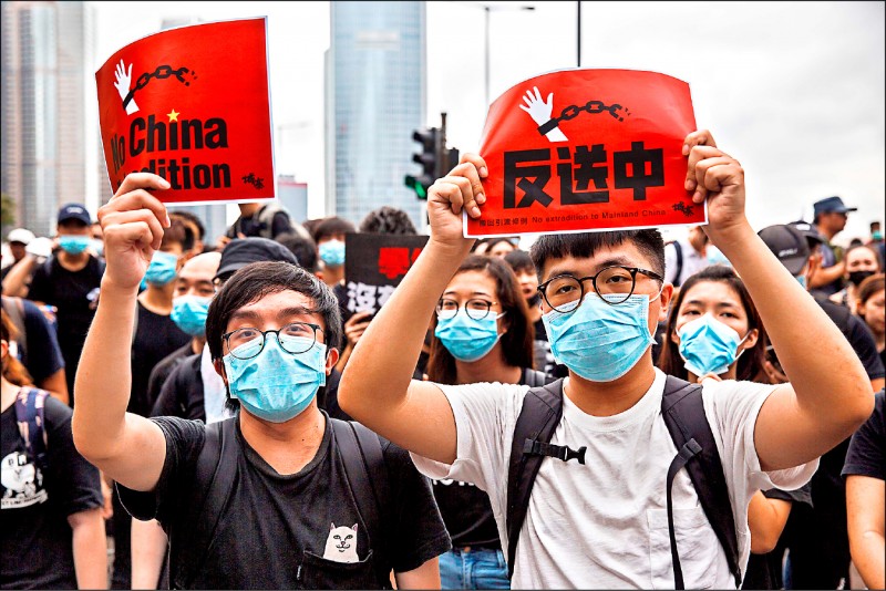 戴口罩的抗爭民眾，十七日持續在香港立法會外聚集，反對香港政府修訂「逃犯條例」（送中條例），要求特首林鄭月娥下台。（法新社）