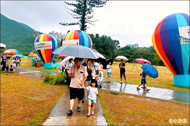 為期九天的石門水庫熱氣球嘉年華昨日閉幕日遇雨攪局，熱氣球迷到場看不到熱氣球立球、升空，只能相約明年再見。（記者李容萍攝）