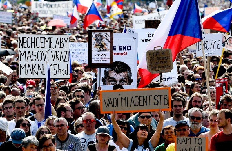 抗議人士高舉寫著「辭職」、「我們受夠了」的旗幟，也有人揮舞捷克和歐盟的旗幟。（歐新社）