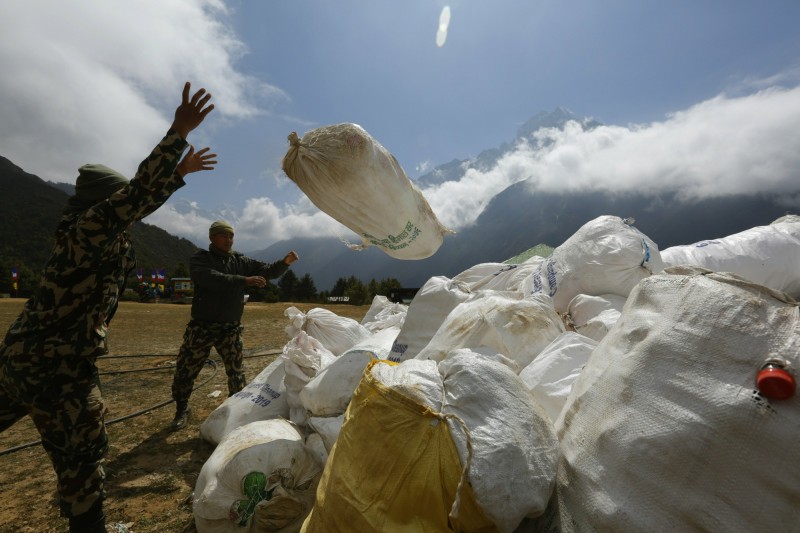 聖母峰近期迎來破紀錄的攀登人潮，登山客攜帶的氧氣瓶、罐頭、帳篷等更讓山上的垃圾量大增。（美聯社）