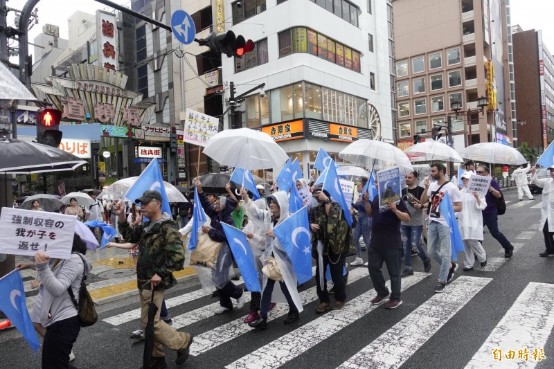 四百多名維族人士今天冒雨走上大阪街頭，抗議中國對維族的人權迫害。（記者林翠儀攝）