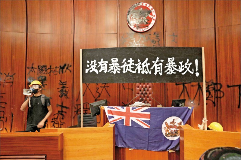 香港示威民眾昨衝撞立法會大樓，並在晚間成功佔領會議廳，並在牆上噴上「太陽花ＨＫ」、「林鄭下台」、「釋放義士」等口號。（法新社）