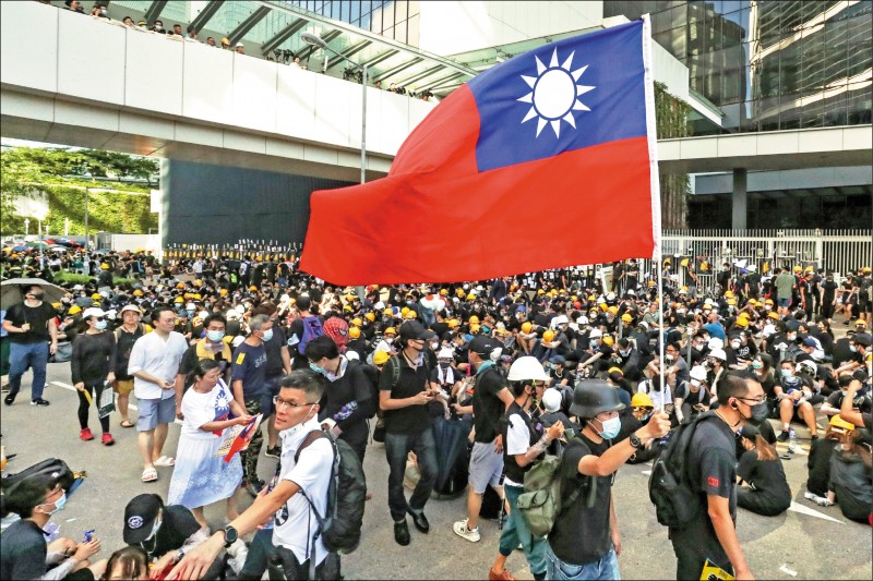 一名示威者在香港立法會外揮舞中華民國國旗。（歐新社）