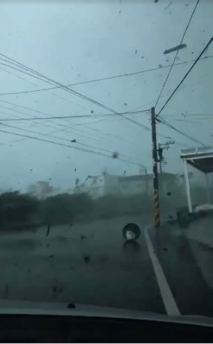 民眾開車遇到龍捲風，車身劇烈搖晃，車外狂風暴雨，物品亂飛，飛沙走石，十分驚悚。（圖擷自爆廢公社）
