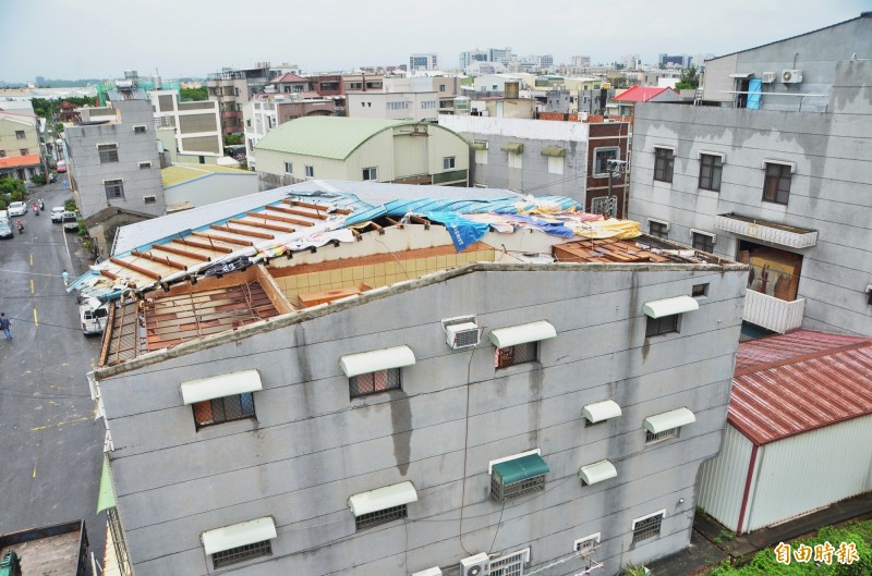 一陣強風，仁德二行里住戶屋頂鐵皮被掀翻、吹掉。（記者吳俊鋒攝）