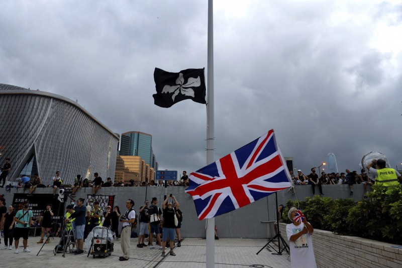 有香港眾志成員在遊行終點處的旗桿上掛上黒色區旗。（美聯社）