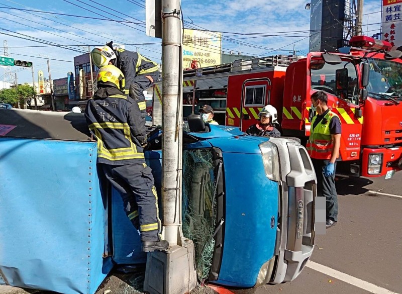 台中市呂姓男子今天早上駕駛小貨車，疑轉彎時車速過快翻覆並撞上路燈桿，消防人員緊急到場救人。（記者陳建志翻攝）