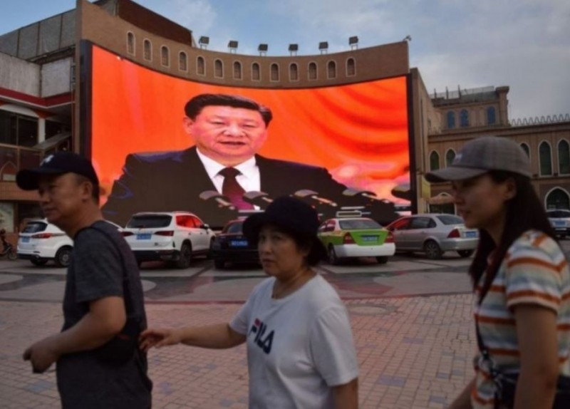 中國國家主席習近平發表講話的影像，在中國新疆街頭播送。（法新社）