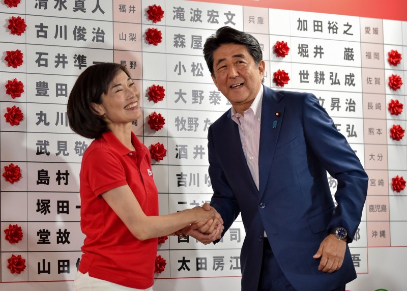 本次日本參議院改選，女性當選人創下史上最高人次。圖為首相安倍晉三與女性當選人丸川珠代握手照片。（法新社）