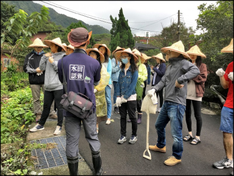 戴上斗笠，隨著導覽人員走入聚落的農村生活。（圖片提供／中華樂音樹環境教育協會）