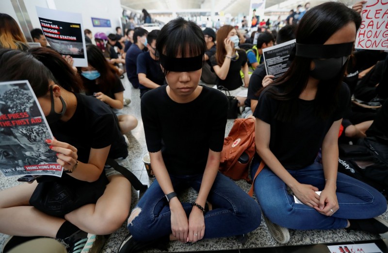 昨日一名女子眼球被港警打爆恐失明毀容，今日萬名示威者在香港國際機場發起示威活動，要求「黑警還眼」。（路透）