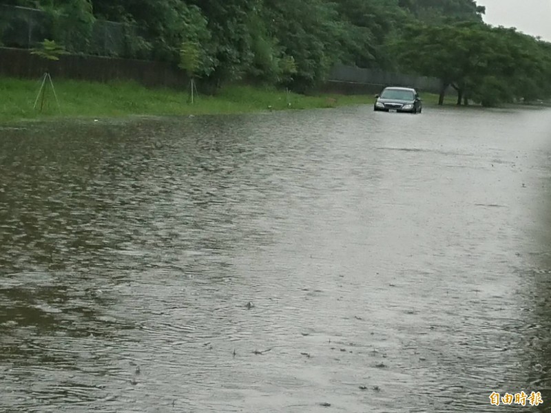 東區部份地區一度積淹水，車陷「河中」。（記者洪瑞琴攝）