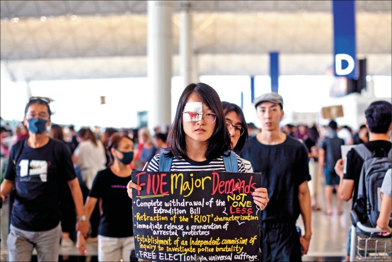 香港赤鱲角國際機場13日湧現逾萬名反送中示威者，響應抗議港警執法過當的「警察還眼」行動，及敦促港府回應五大訴求的「萬人接機」靜坐活動。（路透）