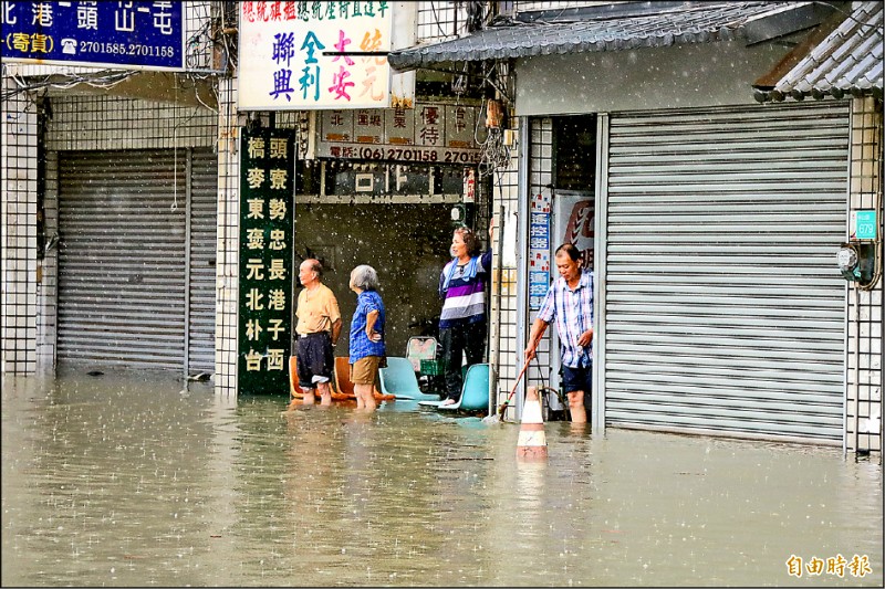 台南仁德昨因強降雨淹成一片，許多住戶在家門張望，期盼積水趕緊消退。（記者萬于甄攝）