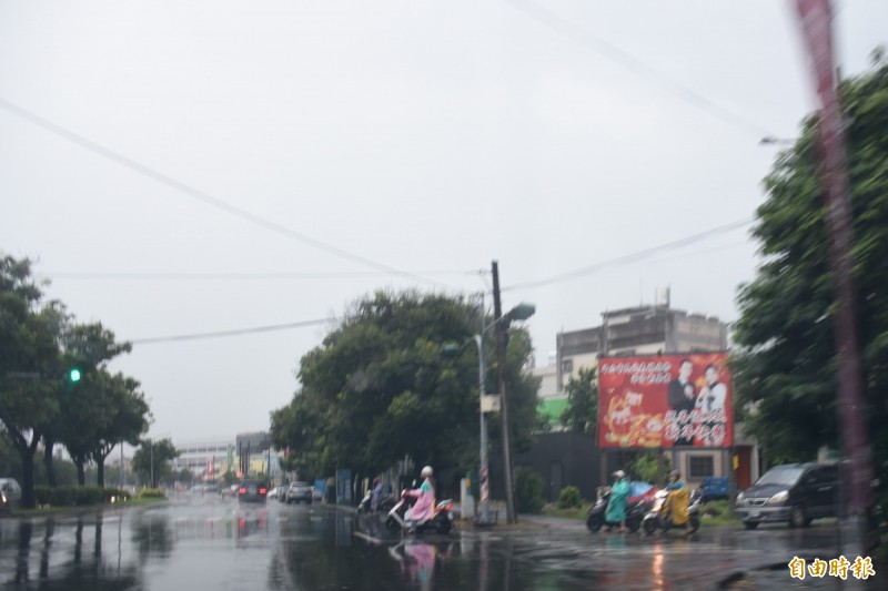 斗六市清晨大雨滂沱，上下班民眾留意安全。（記者林國賢攝）