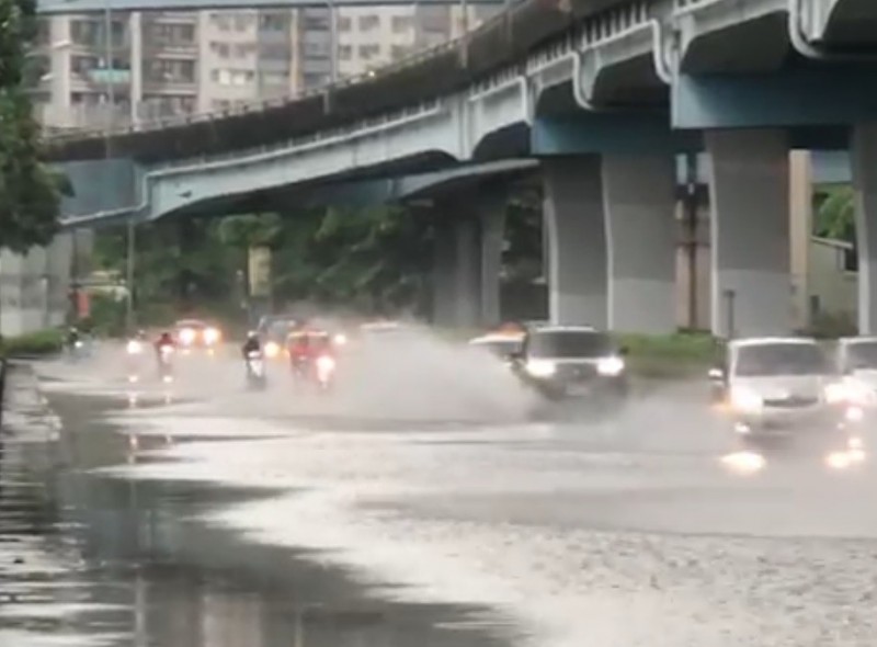 汽車濺起強勁水花，噴到機車騎士，也影響視線，險象環生。（記者洪定宏翻攝）