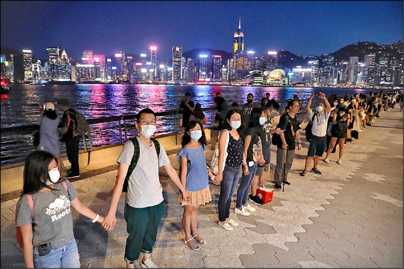 香港人在廿三日晚間以手牽手方式，共築全長逾四十公里的人鏈，呼籲政府回應「反送中」五大訴求。（美聯社）