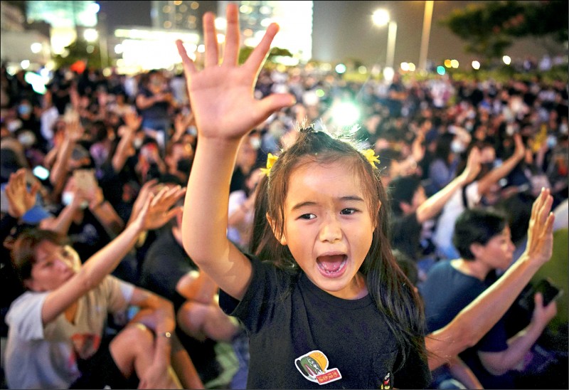 香港網友二十七日晚間在中環的愛丁堡廣場，舉行聲援「新屋嶺被捕者」集會，兒童高呼「五大訴求，缺一不可」口號。（路透）