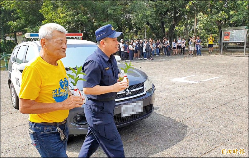 吉貝耍西拉雅族夜祭與孝海祭下月二日起舉行，國內唯一祭祀阿立母的東河派出所，所長岩東華（右）、東河里長吳火生（左）昨以警車護送阿立母分靈返大公廨。（記者王涵平攝）