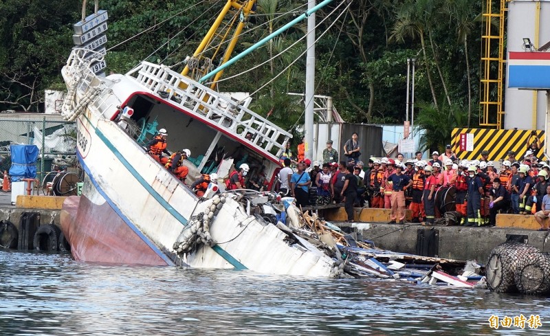 軍艦將漁船拖離坍塌處後推往岸邊靠，搜救人員趕緊上船找尋船體內的失蹤者。（記者羅沛德攝）