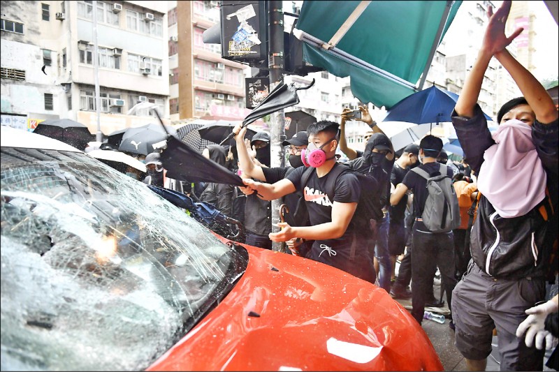 香港民眾六日發起反禁蒙面法遊行，下午約四時在深水埗長沙灣道，一輛計程車突然衝上人行道，連續衝撞多人，計程車隨即遭懷疑司機蓄意撞人的憤怒民眾搗毀，司機也被拉下車痛毆。香港媒體報導，該名司機日前曾參加中國十一國慶活動。
（法新社）