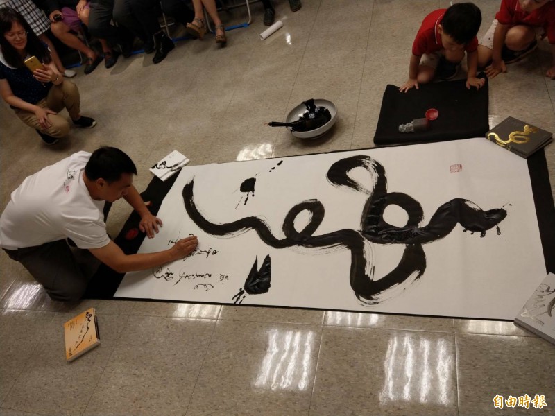 王志揚揮毫「樂」字,鼓勵癌友活出樂趣。(記者黃旭磊攝) 王志揚揮毫「樂」字,鼓勵癌友活出樂趣。(記者黃旭磊攝)