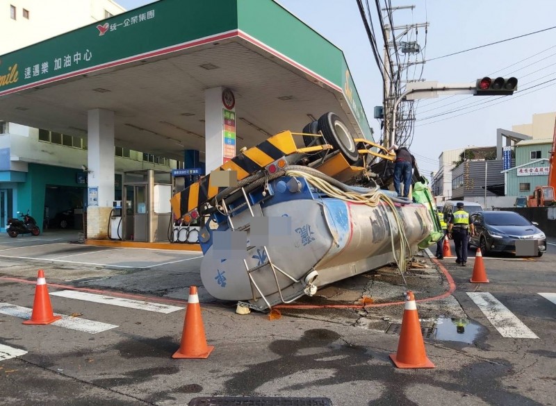 一輛灑水車今天下午行經大里國中、大衛路口時，疑似轉彎失控翻車，差點撞進一旁加油站。（記者陳建志翻攝）