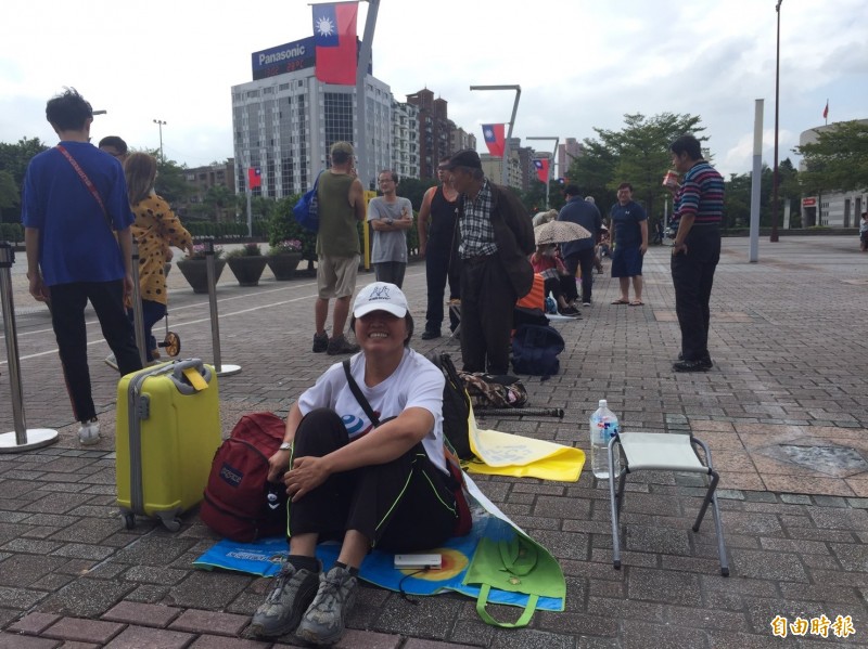 來自台南市仁德區的女柯粉杜美佳（前）為了領取台北市政府第五代「嗡嗡包」，昨天深夜11點多搭乘客運北上，今晨5點半就到市府前廣場排隊。（記者陳璟民攝）