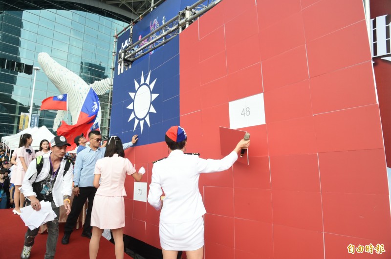 高雄市政府今天在高雄展覽館舉辦國慶升旗典禮,韓國瑜致詞過程中,大幅國旗拼圖看板突然掉落,一旁工作人員立即上前將國旗拼圖扶正掛回去,巨幅國旗險些打到韓國瑜本人。(記者張忠義攝) 高雄市政府今天在高雄展覽館舉辦國慶升旗典禮,韓國瑜致詞過程中,大幅國旗拼圖看板突然掉落,一旁工作人員立即上前將國旗拼圖扶正掛回去,巨幅國旗險些打到韓國瑜本人。(記者張忠義攝)