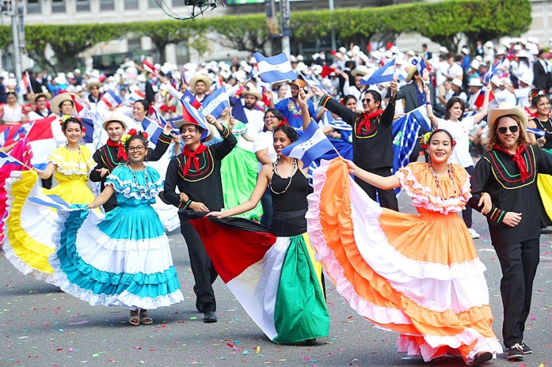 Hondurans wearing traditional costumes wave flags as they parade past the Presidential Office Building in Taipei yesterday.
Photo: CNA Hondurans wearing traditional costumes wave flags as they parade past the Presidential Office Building in Taipei yesterday.
Photo: CNA
