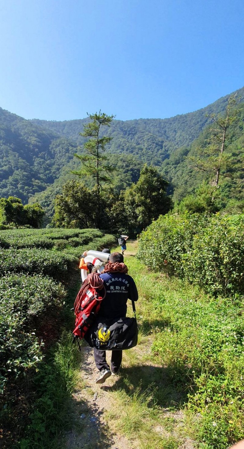 南投縣消防局潛水隊員帶重達30公斤裝備，走2公里登山步道，才到帖比倫瀑布。（南投縣消防局提供）