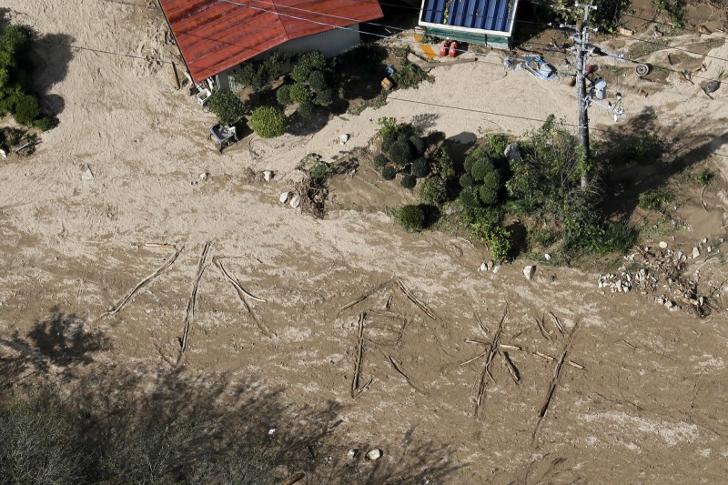《共同社》直升機勘災時，赫然發現有人在泥濘的地上寫出大大的「水、食物」求救訊息。（美聯社）