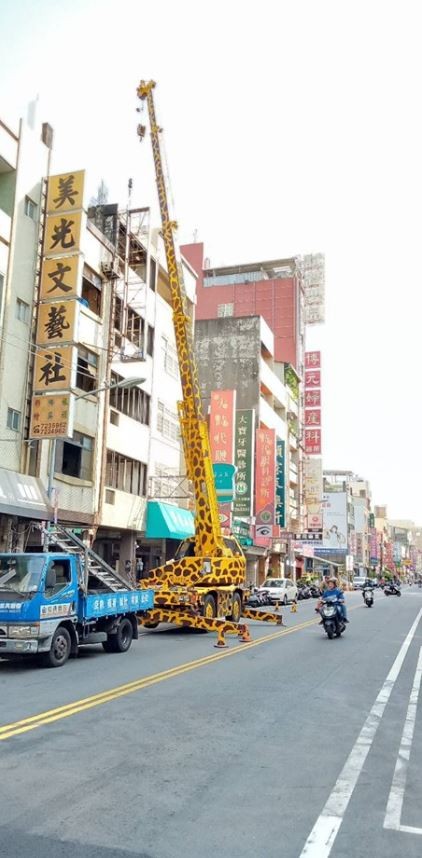 有台巨大的黃色吊車，在路邊進行吊掛作業。（圖擷自爆廢公社公開版）