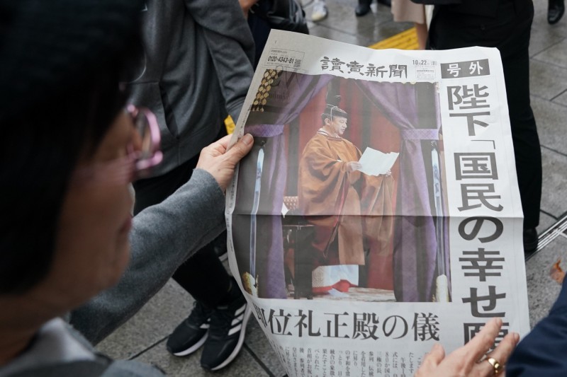 日皇德仁今天完成「即位禮正殿之儀」，許多民眾在東京都各處爭搶各大紙媒發送的「號外」。（歐新社）