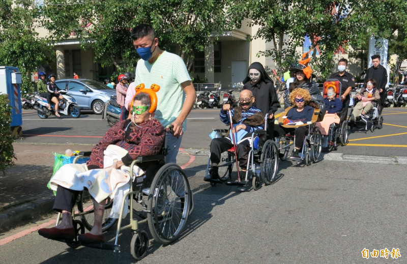 萬聖節快到了，豐原醫院護理之家的阿公阿嬤變裝坐輪椅外出討糖果，十分吸睛　。（記者歐素美攝）