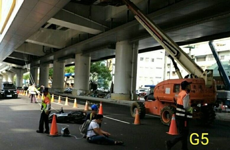 男子被掉落的輔助繩勒喉造成摔車，坐在馬路上。（擷取自網路）