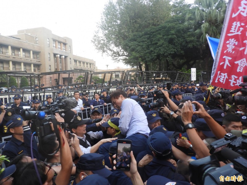 中華民國退休警察總會長耿繼文企圖翻越拒馬被警方擋下。（記者陳鈺馥攝）