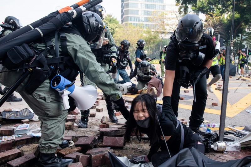 中國力挺港警「嚴正執法」，認為港警是在「依法保障港民生命與財產安全」。圖為18日香港警方在理工大學周邊壓制、逮捕年輕示威者。（彭博）