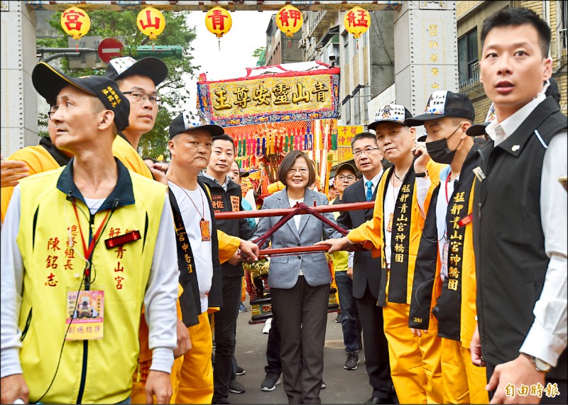 蔡英文總統（中）昨前往台北市艋舺青山宮參拜並擔任扶轎官，在內政部長徐國勇及立委林昶佐陪同下，緩步起轎前行，受到民眾熱烈歡迎。（記者簡榮豐攝）