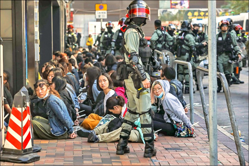 香港鎮暴警察十八日在香港理工大學校園內外，強行拖走拘捕多名示威者。（法新社）